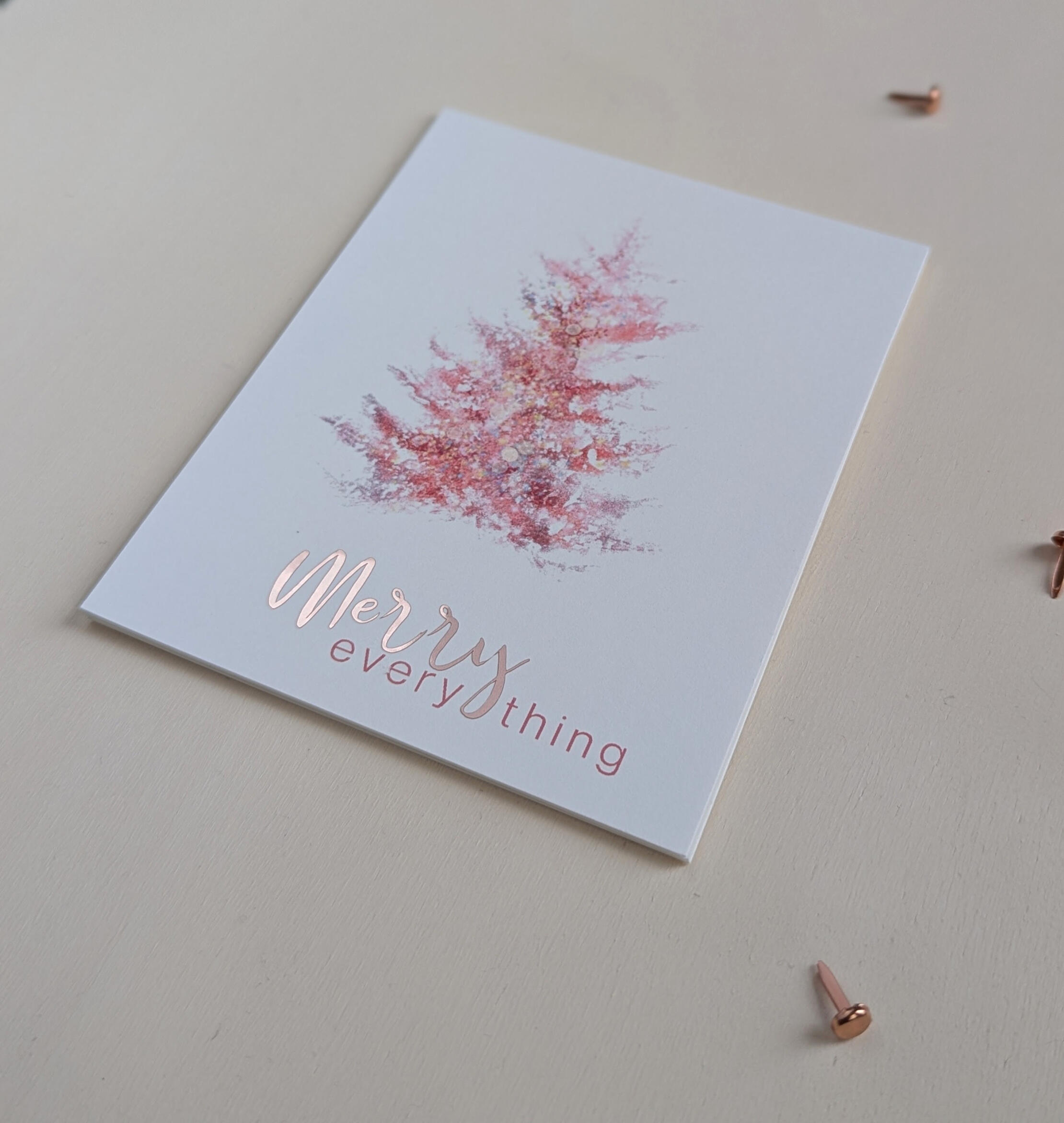 Blush pink watercolor evergreen tree centered on a Christmas postcard with the greeting "Merry Everything." A luxury handmade Christmas card.